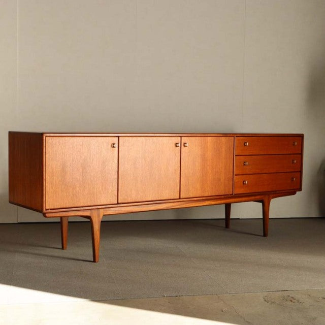 Mid-century British teak sideboard by Younger featuring clean lines, wood grain doors, and tapered legs.