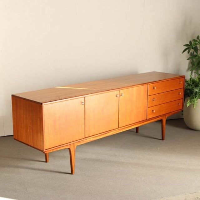 Vintage teak sideboard by Younger, mid-century British design with clean lines, wood grain top, four sleek legs, two doors,.