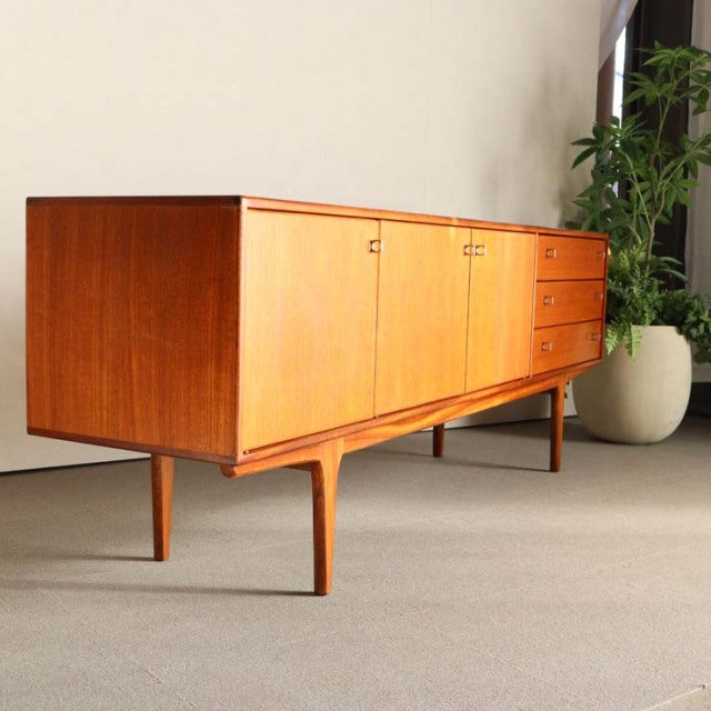 Vintage teak sideboard by Younger, British mid-century design with sleek wood grain and tapered legs, inspired by Denmark.