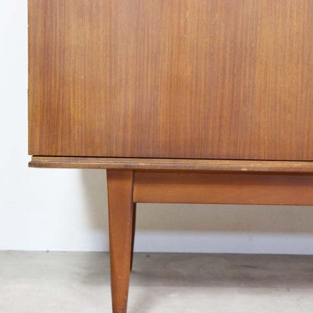 Mid-century British vintage teak sideboard showcasing warm wood grain and tapered legs from Denmark design influence.