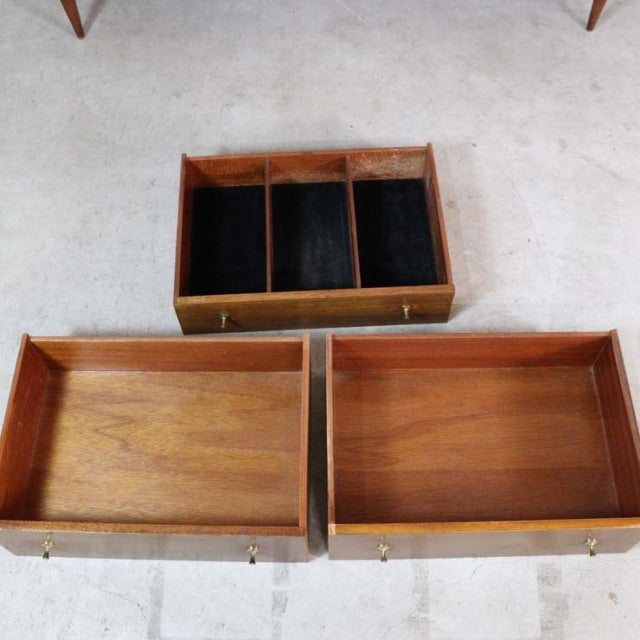 Three mid-century British vintage teak sideboard drawers with black felt-lined compartments and visible wood grain.