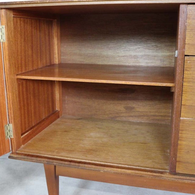Open teak wood sideboard compartment showcasing rich wood grain and mid-century British vintage craftsmanship from Denmark.
