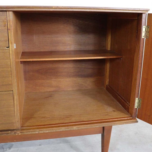 Open British mid-century vintage teak sideboard cabinet interior with single adjustable shelf and tapered legs.