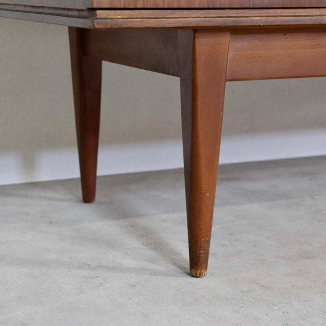 Mid-century British vintage teak sideboard leg with tapered design and natural wood grain texture.