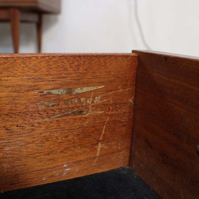 Close-up of vintage teak wood grain and craftsmanship details inside a British mid-century sideboard drawer.