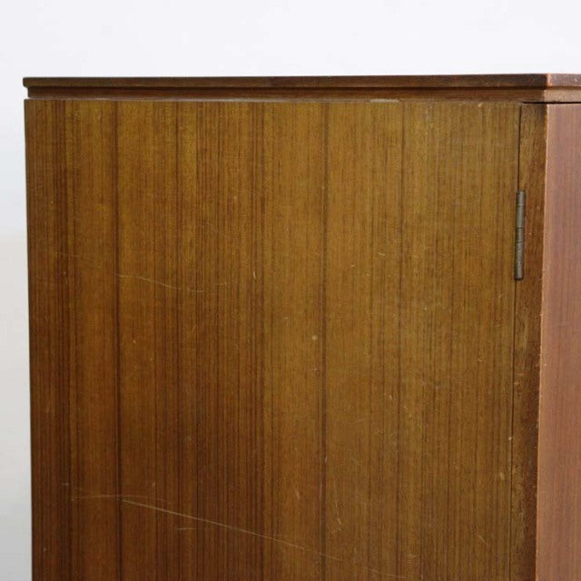 Mid-century British vintage teak sideboard with smooth wood grain and slim vertical handles.