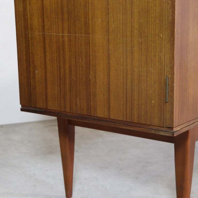 Vintage British mid-century teak sideboard with rich wood grain and tapered legs.