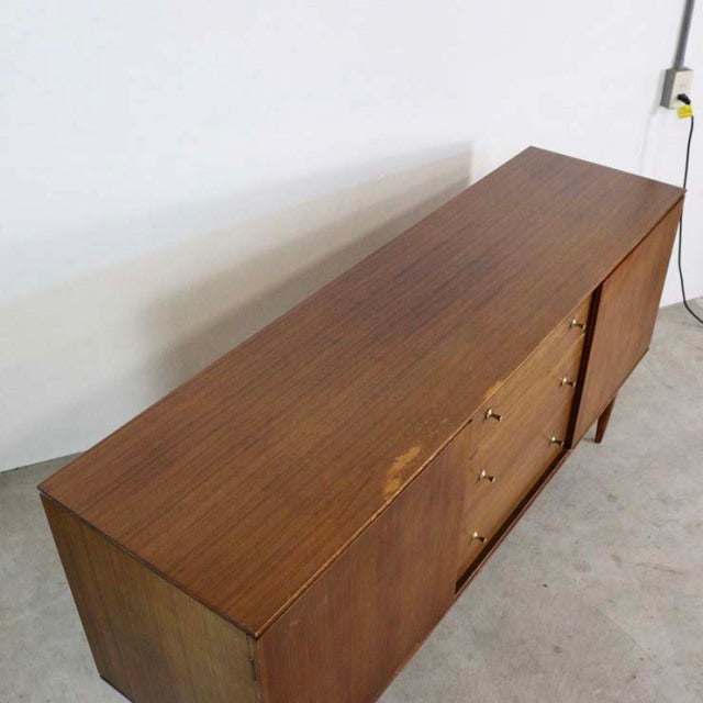 Mid-century British vintage teak sideboard with clean lines, wood grain top, and slim tapered legs.