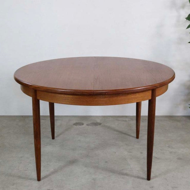 Vintage G-Plan mid-century teak dining table with round expandable top and tapered legs, British design.