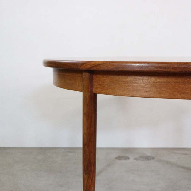 Vintage G-Plan teak dining table with smooth rounded edge, slender mid-century British wood legs, and rich wood grain from.