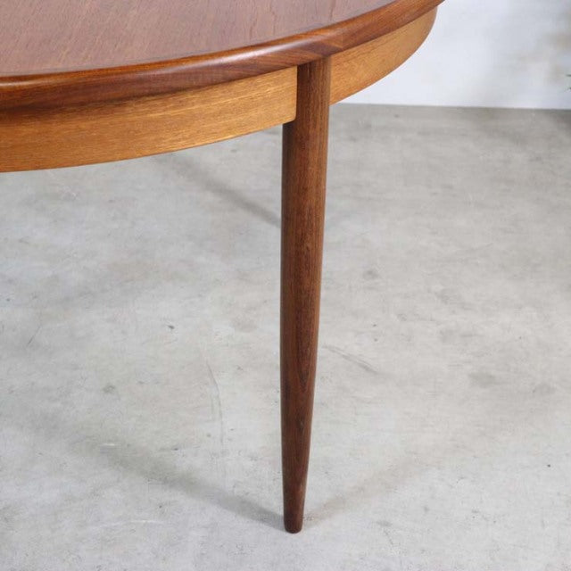 Vintage British mid-century teak dining table leg with tapered design and rich wood grain texture.