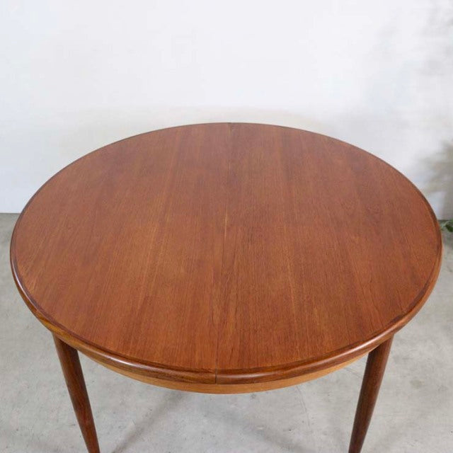 Round vintage teak dining table with smooth grain, tapered mid-century British legs, G-Plan design.