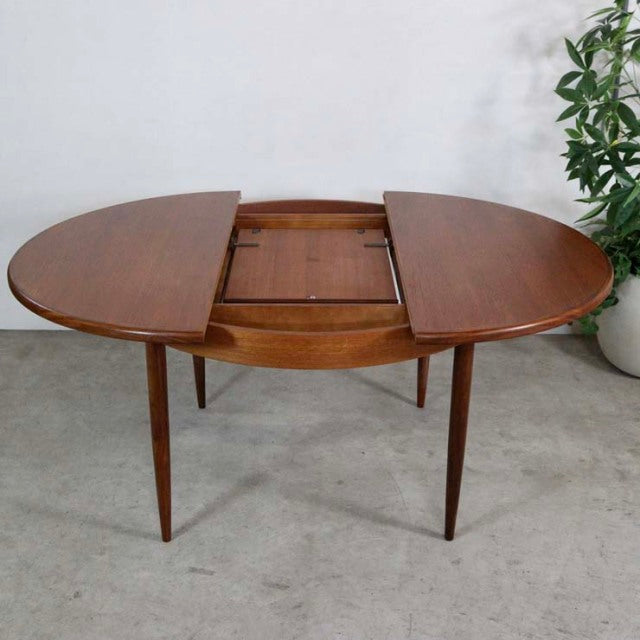 Vintage mid-century G-Plan teak dining table with oval shape, extending top, and tapered legs.