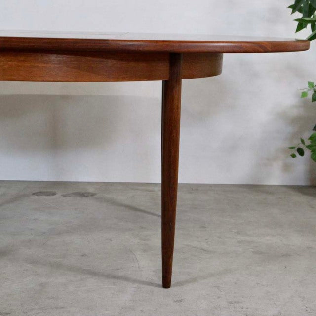 Mid-century British G-Plan vintage teak dining table with tapered round legs and smooth wood grain finish.