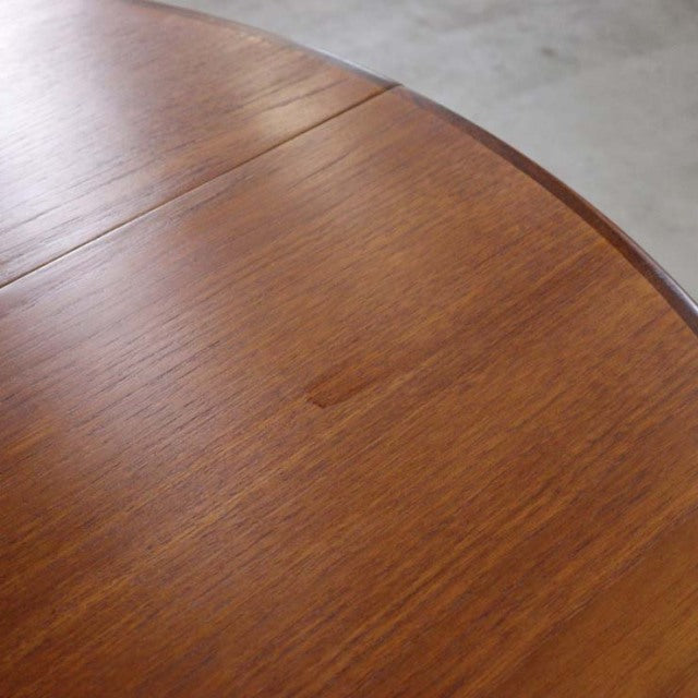 Vintage teak G-Plan mid-century British dining table with smooth oval top and rich wood grain.