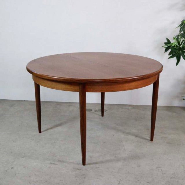 Vintage G-Plan mid-century teak dining table with round top and tapered British legs from Denmark.