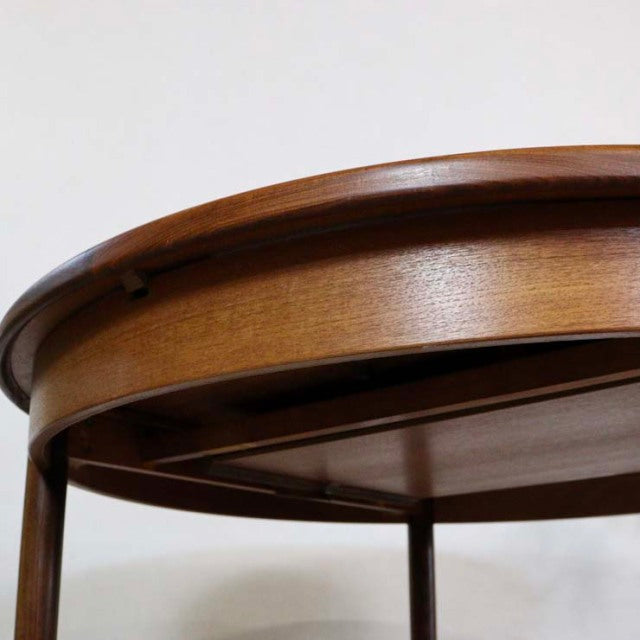 Vintage G-Plan mid-century teak dining table with smooth wood grain and tapered round legs, British design.