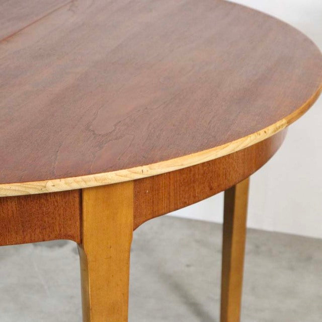 Round vintage teak dining table with smooth wood grain and tapered mid-century British legs.