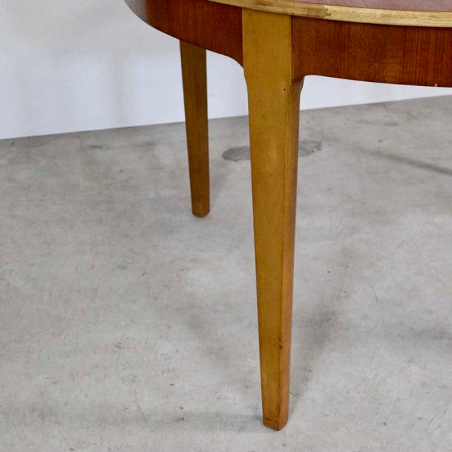 Mid-century British teak dining table leg showing smooth grain and rounded edge craftsmanship.