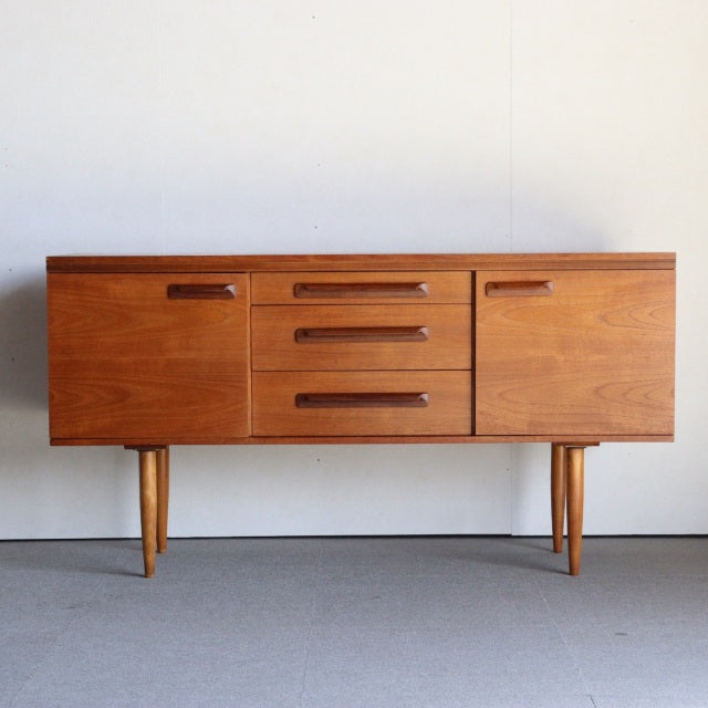 Vintage mid-century teak sideboard by William Laurence, British design with clean lines, natural wood grain, and tapered.