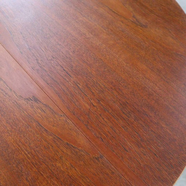 Round mid-century British vintage teak dining table top with rich wood grain detail.