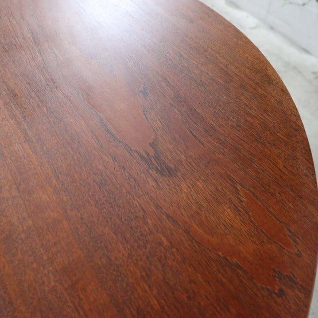 Round vintage teak dining table top showing rich wood grain and smooth mid-century finish.