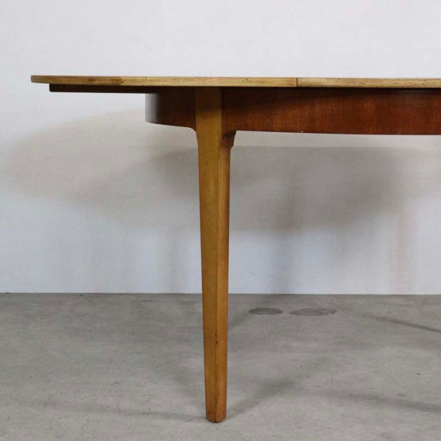 Mid-century British vintage teak round dining table leg with smooth wood grain and tapered form.