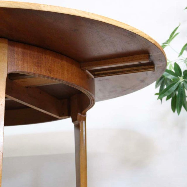 Mid-century British vintage teak round dining table with visible wood grain and sturdy legs, Denmark style.