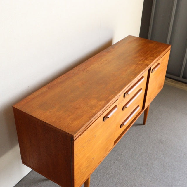 Mid-century British vintage teak sideboard by William Laurence with natural wood grain, clean lines, and tapered legs.
