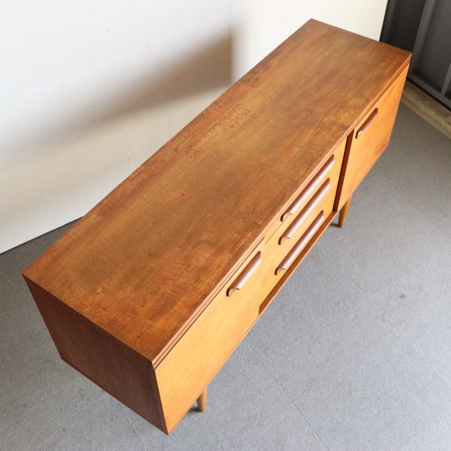Vintage teak mid-century sideboard by William Laurence, British-Denmark design, smooth wood grain, tapered legs, sleek.