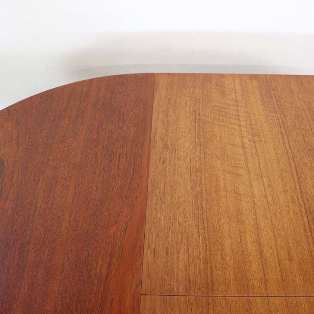 Vintage mid-century British teak round dining table top showcasing rich wood grain and smooth finish.