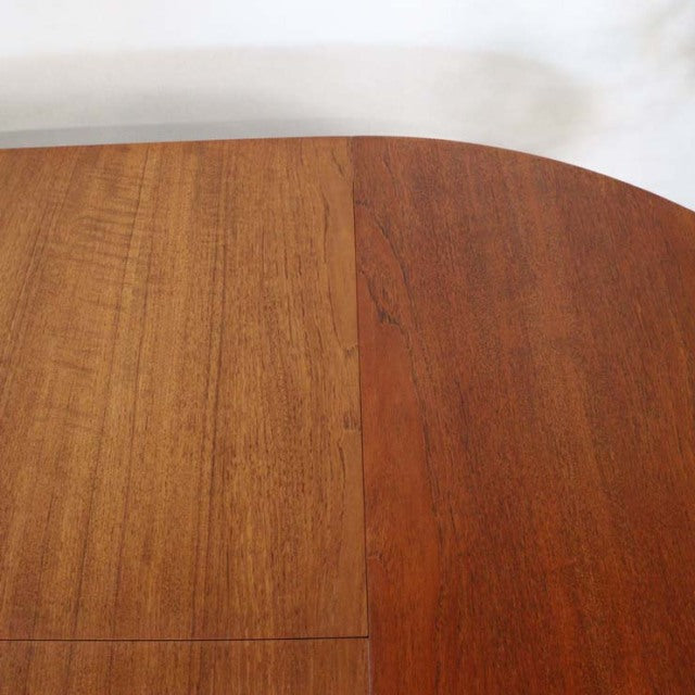 Mid-century British vintage teak round dining table with rich wood grain and smooth rounded edges.