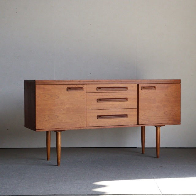 Vintage teak sideboard by William Laurence with clean mid-century British design, tapered legs, and visible wood grain.