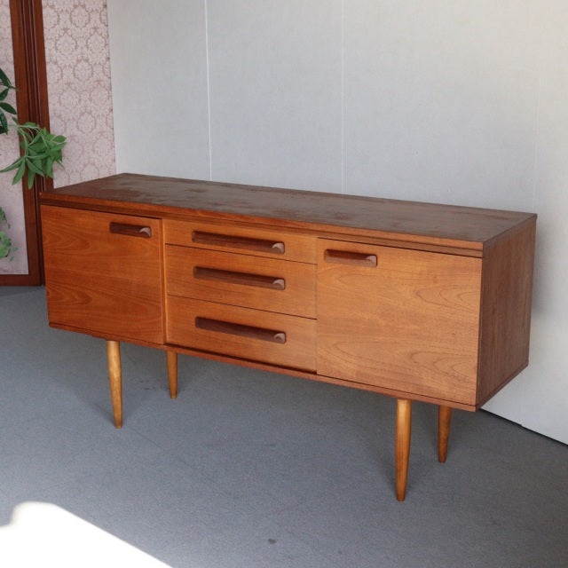 Vintage mid-century teak sideboard by William Laurence, British-Denmark style with clean wood grain, tapered legs, and three .