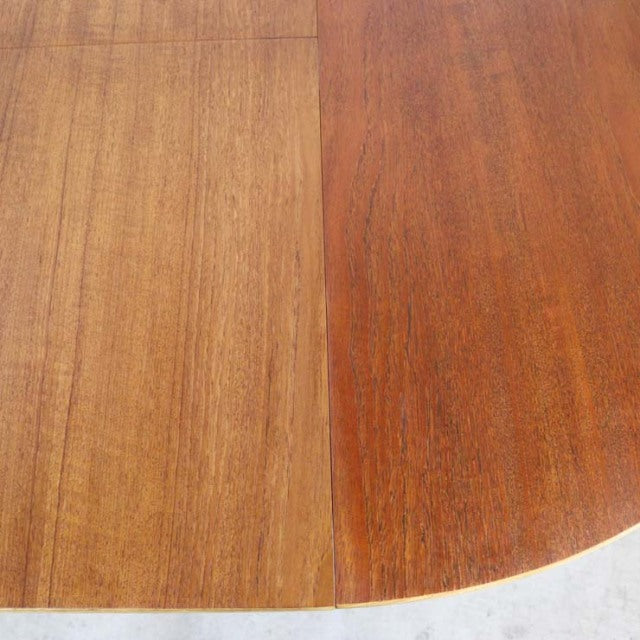 Mid-century British vintage teak round dining table with rich wood grain and smooth edge.