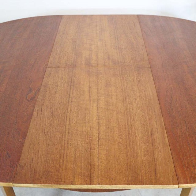 Vintage teak round dining table with visible wood grain and smooth mid-century British design from Denmark.