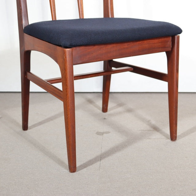 Vintage mid-century teak dining chair from British Denmark design with slender tapered legs and navy upholstered seat.