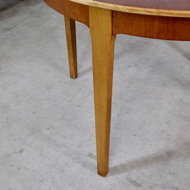 Mid-century vintage teak dining table leg with warm wood grain, British and Danish design influence.