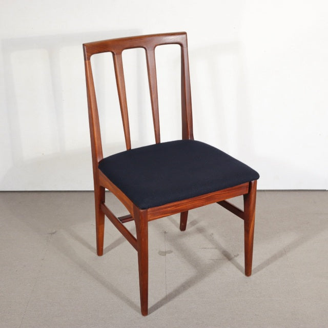 Vintage teak dining chair with black cushioned seat, slender mid-century British design, clean lines, and vertical slat back .