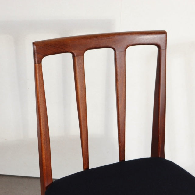 Mid-century British vintage teak dining chair with angled backrest slats and black upholstered seat.