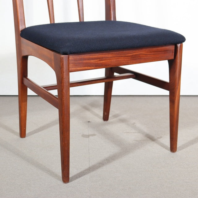 Vintage teak mid-century dining chair with black upholstered seat, slender tapered legs, and classic British-Denmark design.