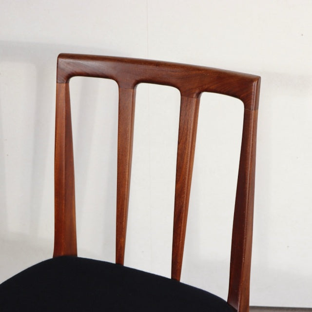 Vintage teak dining chair with British mid-century design, slender vertical back slats, and smooth wood grain detailing.