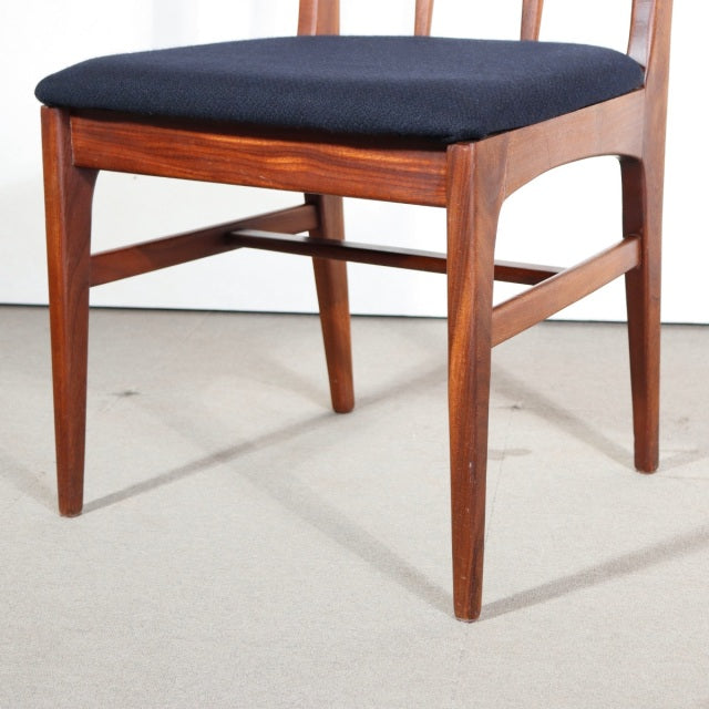 Vintage mid-century teak dining chair with black upholstered seat, tapered legs, and British-Denmark design influences.
