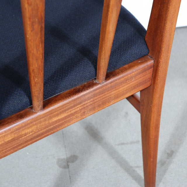 Mid-century British vintage teak dining chair with tapered legs, smooth wood grain, and navy blue upholstered seat.