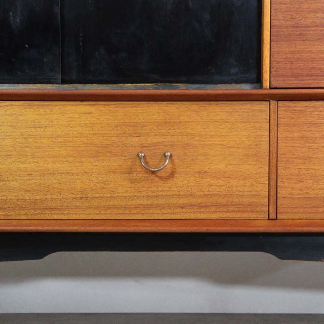 Mid-century vintage British teak sideboard with smooth wood grain, brass drop handle, and tapered legs.