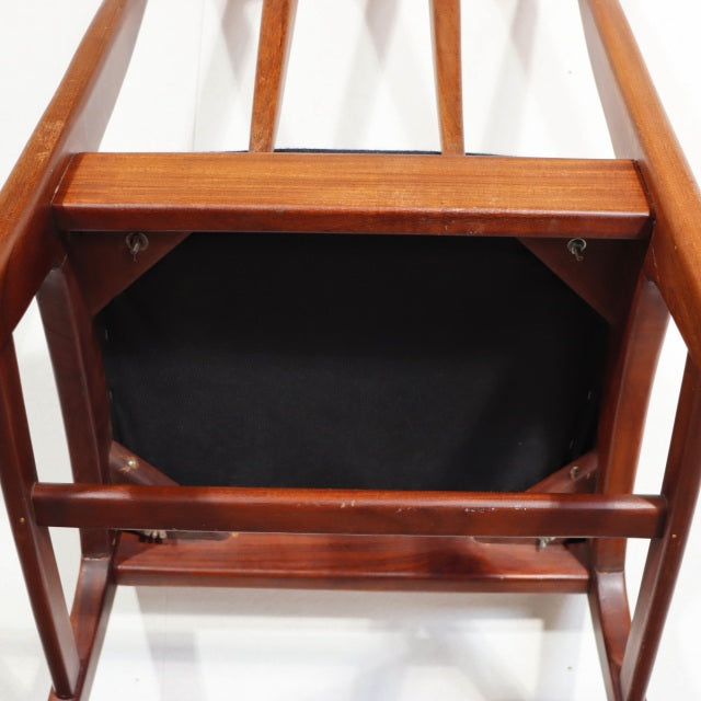 Mid-century British vintage teak dining chair viewed from below, showcasing wood grain, sturdy legs, and frame craftsmanship.