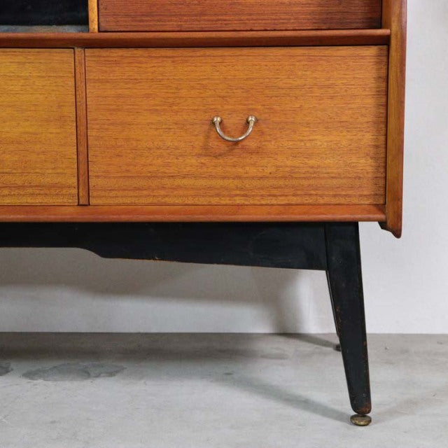 Mid-century British vintage teak highboard by G-Plan with rich wood grain, tapered black legs, and brass handle detail.
