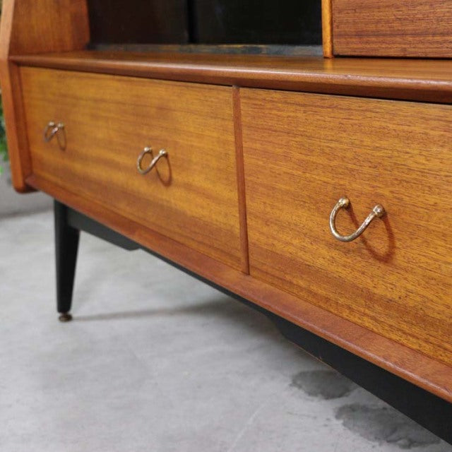 Vintage British mid-century G-Plan teak sideboard with rich wood grain, sleek tapered legs, and elegant curved metal handles.
