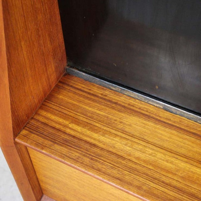 Close-up of vintage G-Plan teak wood with rich grain and smooth finish, showcasing mid-century British design details.