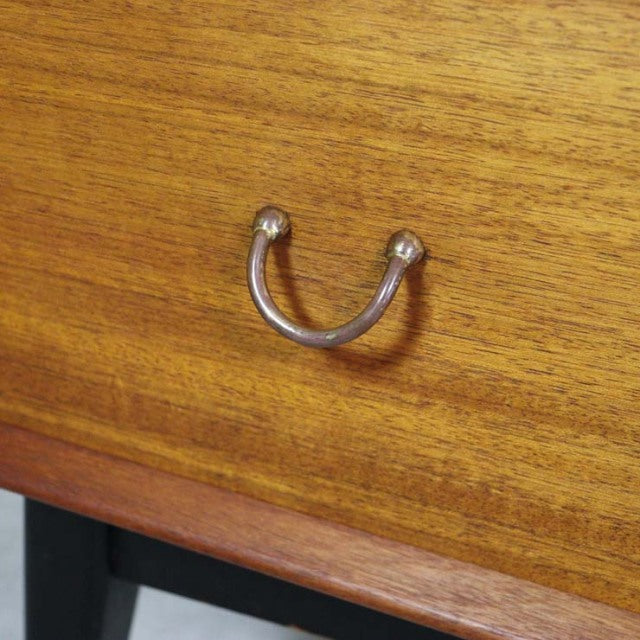 Close-up of mid-century teak wood drawer with visible grain and curved metal handle from British G-Plan vintage furniture.